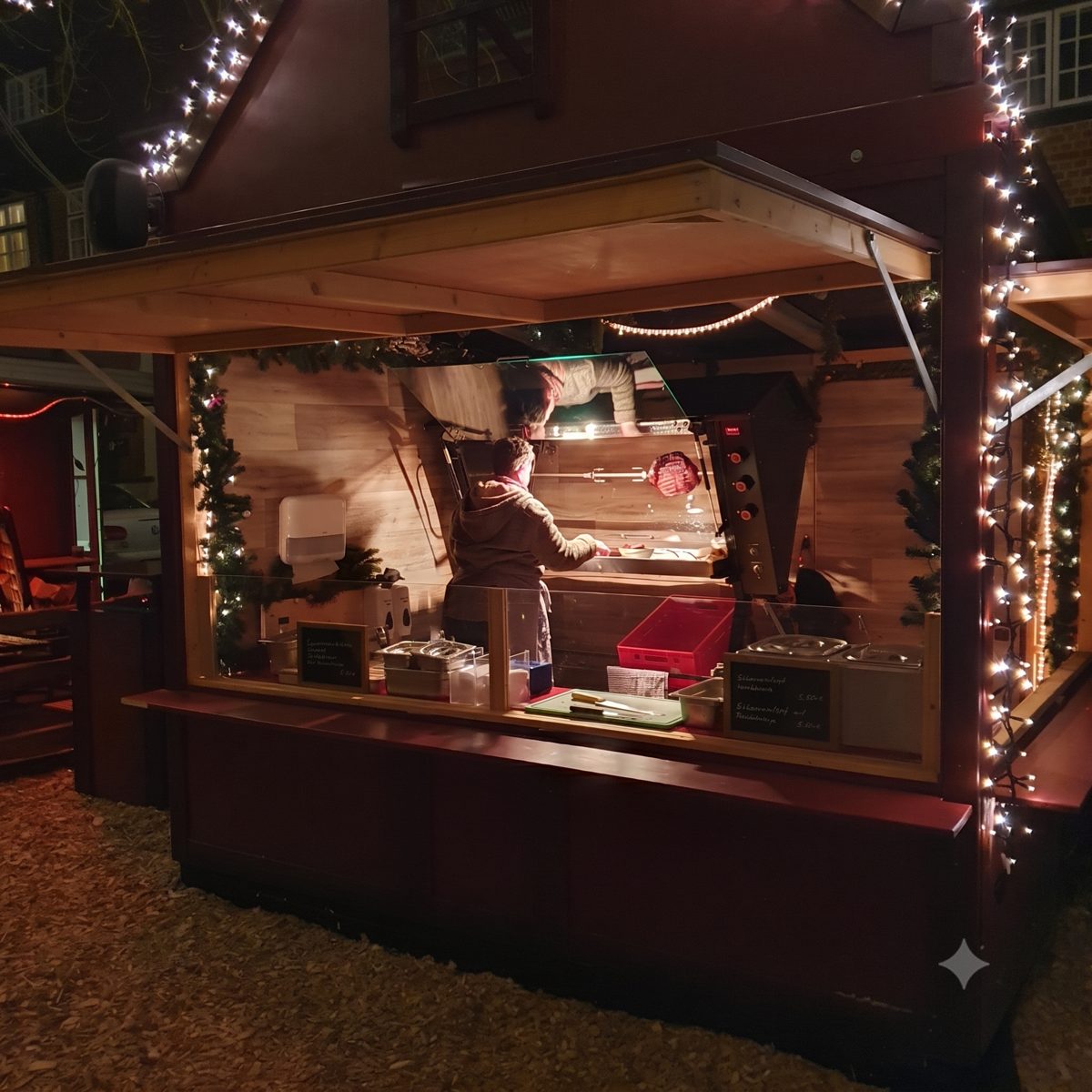 Beleuchtete Streetfood-Bude auf einem Weihnachtsmarkt